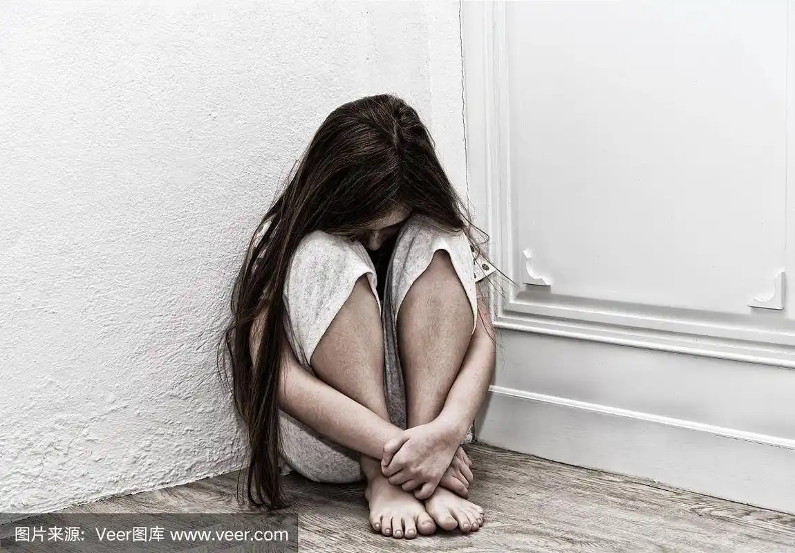 被忽视的孤独的孩子靠在白色的墙上.小女孩在角落里哭.暴力的概念.