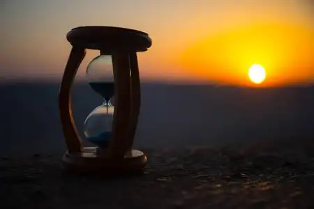 时光流逝的沙漏云. 一个沙漏在明亮的蓝天前面,白云飘过. 时间概念.