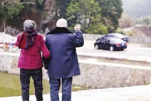 留守的老人向离村的年轻人挥手告别