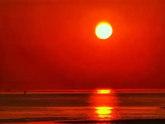 海面泛起金光;天边有霾天上有较薄的云时則火红火红的太阳从海上徐徐