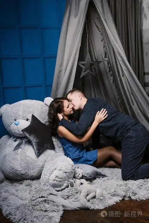 年轻欢快的欧洲情侣在爱拥抱和亲吻, 在装饰与心工作室在情人节, 约会