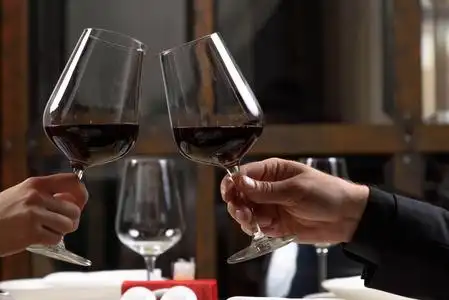红酒特写夫妻俩在餐厅喝红酒.戴着眼镜的特写手照片