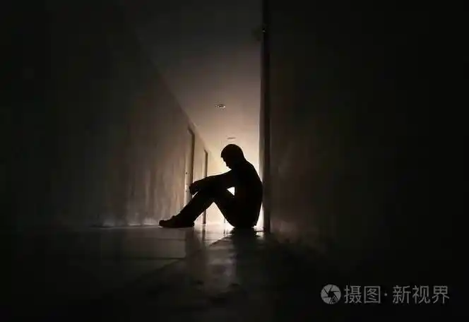 坐在住宅楼走道上的沮丧男人的侧影悲伤的男人哭泣戏