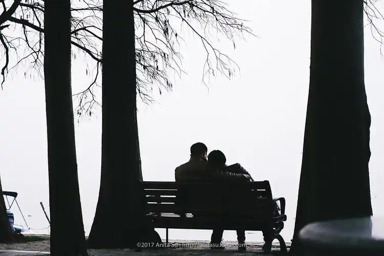 东湖,一对夫妻安静地相互依靠着,说着悄悄话,享受着湖面吹来的微风.