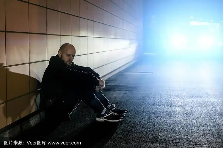 抑郁孤独悲伤的男人坐在地下街道隧道