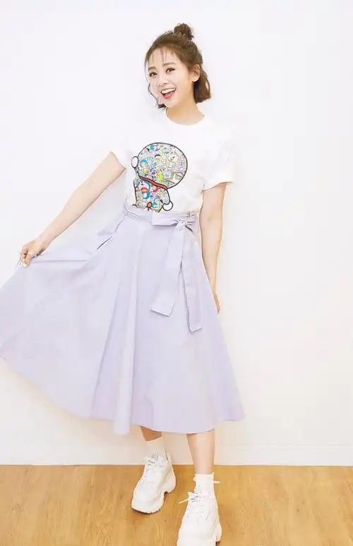 吴映洁身穿白色带图案t恤,搭配浅紫色半身裙,脚穿白色运动鞋,一股清新