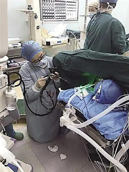 手术中孙文静医生跪地为患者插管进行营养支持 医院供图