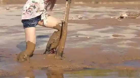 美女穿红色雨靴泥河里摸鱼拔不出腿