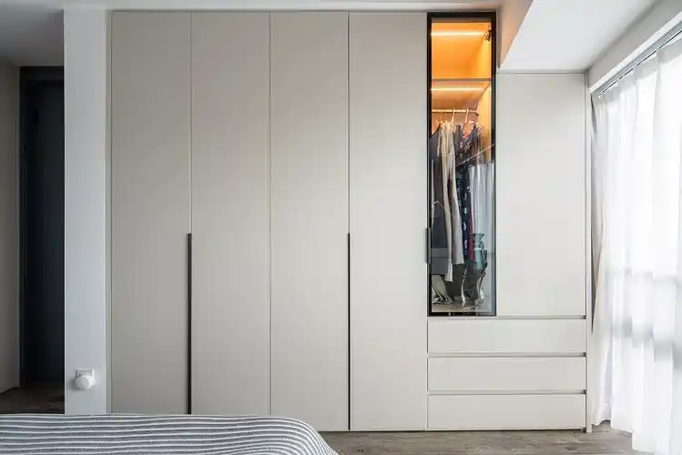 床尾做了一面墙的衣柜,顶天立地式的柜子收纳空间更足,玻璃门的柜门