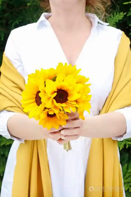 女人拿着一束向日葵