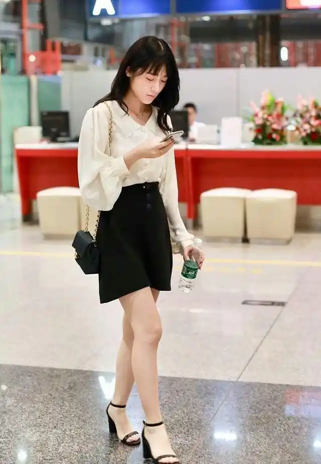 徐娇上半身穿着一件白色的衬衫,比较的成熟的感觉,下半身搭配的是一条