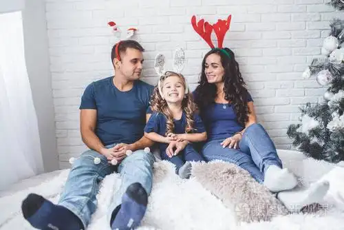 圣诞全家福照片.父亲, 母亲和女儿都戴着圣诞节有趣的角照片-正版商用