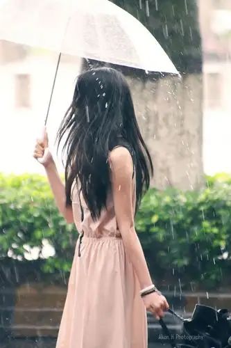 下雨了 女孩撑伞走过的图片