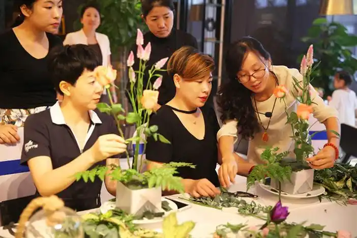 客户们开始热情参与到插花艺术里,在摆满材料的diy工艺台上开始制作专