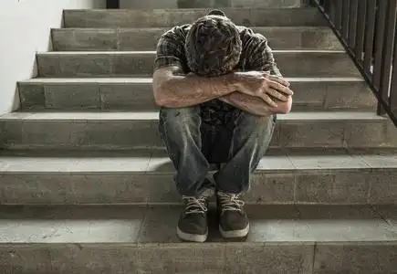 绝望的男人坐在户外黑暗肮脏的街角楼梯上感到不舒服精神健康观念中的