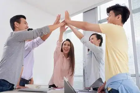 快乐的亚洲年轻人互相给予高五照片