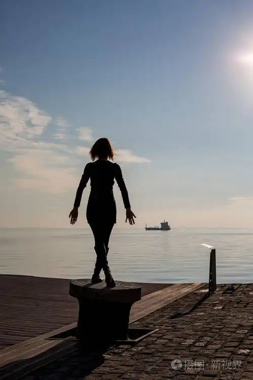 在希腊塞萨洛尼基的停靠杆上, 跳舞的年轻漂亮合身的女子的背部观看.