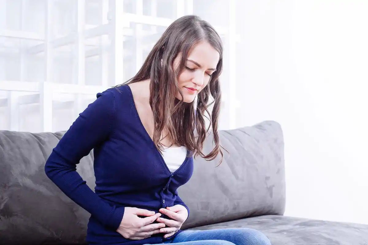 家里沙发上胃疼的年轻女人女生痛经肚子痛