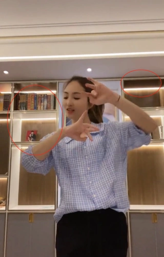 视频中,李汶桐穿着蓝白格子上衣正在跳舞,身后的巨大柜子上都装满了灯