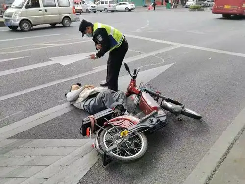 画面中,一名老人仰面倒在了马路一侧,所骑的电动自行车倒在一旁,而在