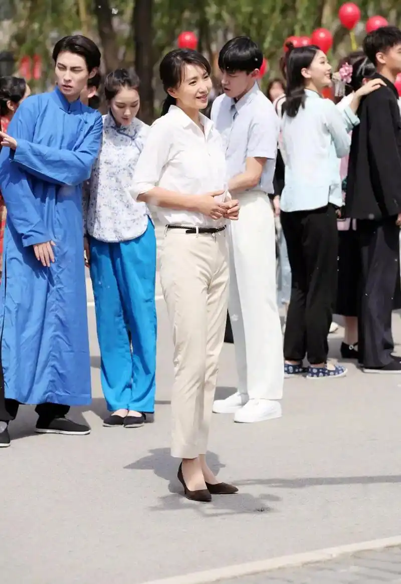 超级基础的白衬衫和米白色休闲裤,衬得陈好身姿挺拔,气质如兰.