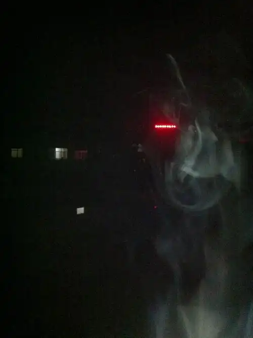 昨晚一个朋友在楼顶看夜景抽烟,他随手拍的照片中烟圈里有鬼影是怎么