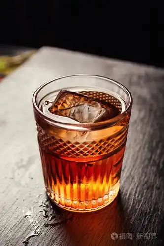 一杯威士忌白兰地或白兰地上面有柠檬和冰块站在酒吧柜台上