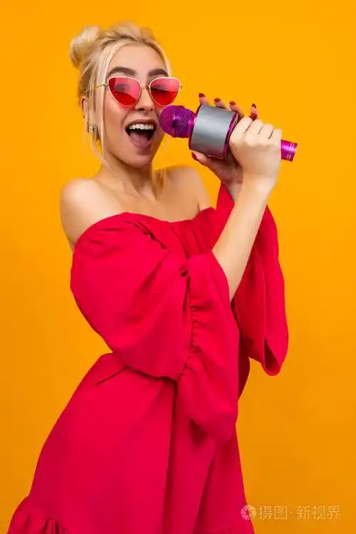 欧洲优雅女孩身穿红色连衣裙露肩戴着复古眼镜手里拿着麦克风唱歌