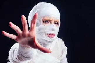 迷人的木乃伊女人全身缠着绷带,黑色背景