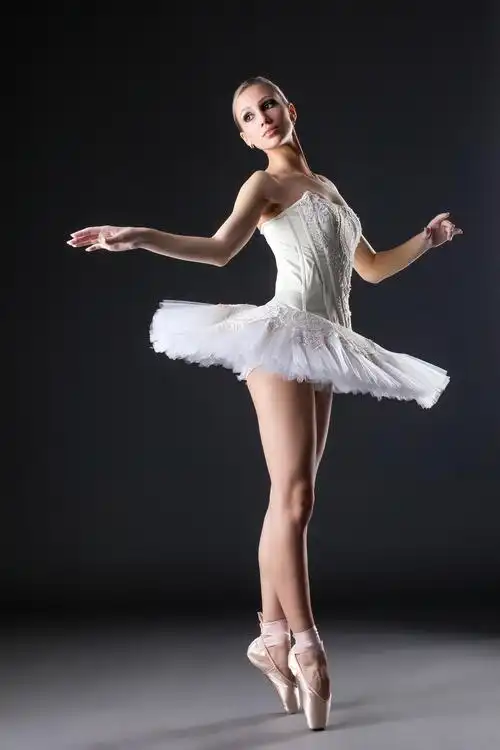 可爱的年轻芭蕾舞演员 舞蹈在演播室里 在灰色的背景上的图像