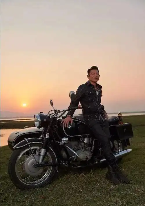 摩托车,背后是夕阳落山的景色,谁能猜出这个时候的刘德华已经是五十多