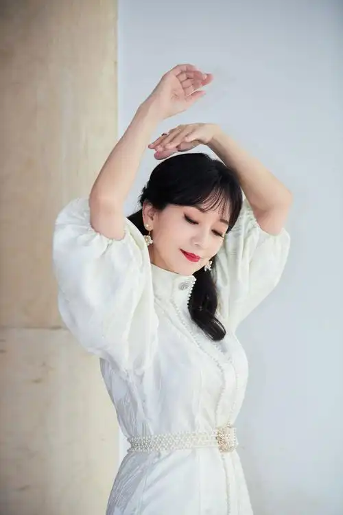 赵雅芝白色泡泡袖短裙秀美腿 持粉色玫瑰人比花娇