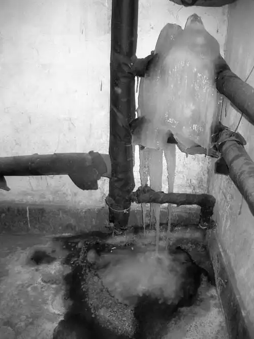 楼道里的一户一阀供暖管线被冻裂结成大冰溜.