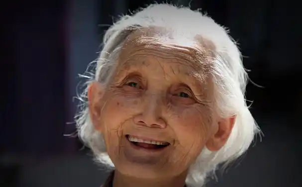 山西乡宁山村小院柴堆前坐着一位80多岁的白发亲娘.