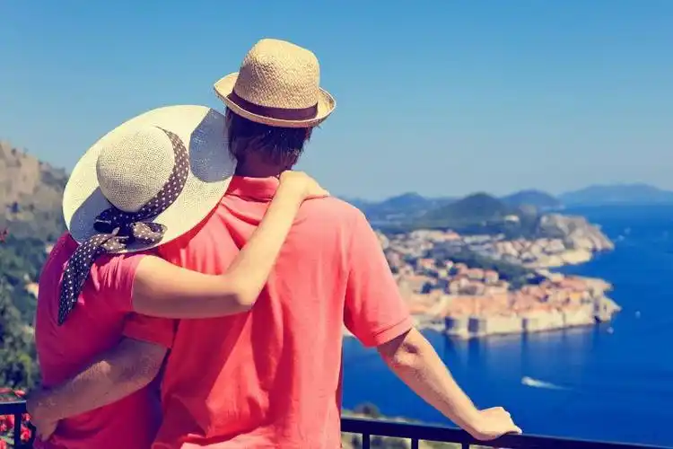 恩爱的夫妻在在海边看着蓝色的大海