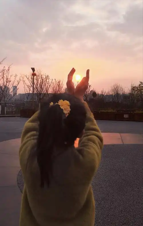 小女孩托起太阳背影黄昏日出