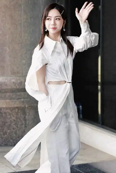 邓紫棋外面搭配了一件镂空风格的衬衣裙,能够让她秀出纤细的腰部线条