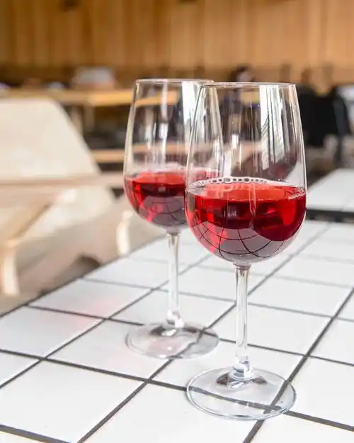 两杯红酒,放在餐馆或酒吧的白桌.