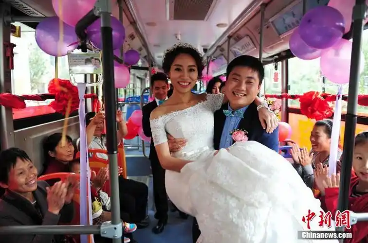 图为新郎抱起新娘下车,车上市民祝福新人.