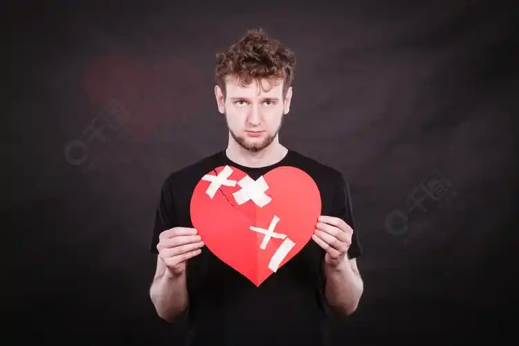 心碎的概念不快乐的悲伤男人拿着粘在爱情标志符号上石膏修复的人情味