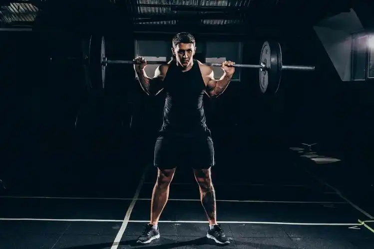 在健身房举杠铃的男人