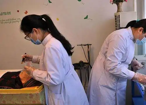 图为正在给逝者化妆的女孩