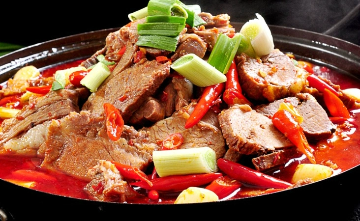 在黑色的碗里,有一碗麻辣羊肉汤,看着辣味十足.