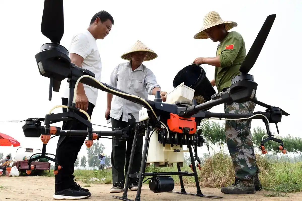 工作人员为飞防作业的植保无人机添加农药. 责编:马婉莹
