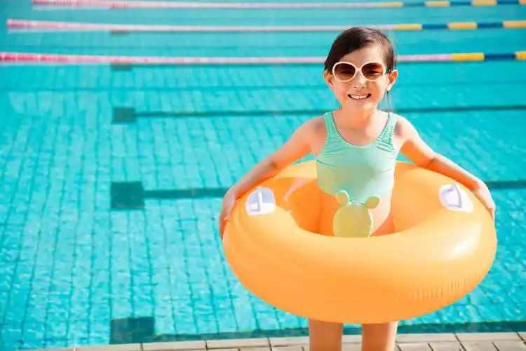 快乐的小女孩在游泳池里玩刷亲子游泳微笑的小女孩