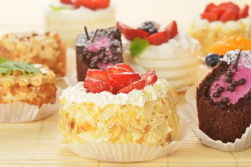 小蛋糕,小奶油蛋糕和竹表布的莓果