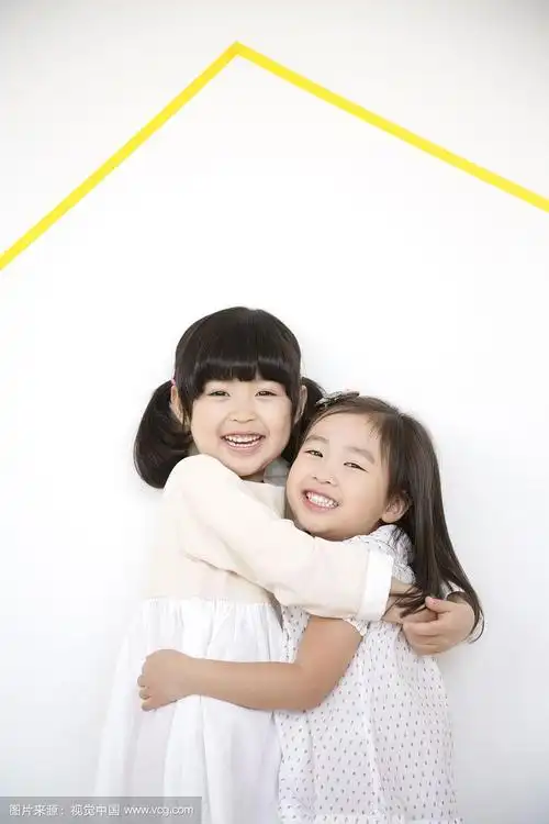 两个小女孩拥抱着,靠墙站着