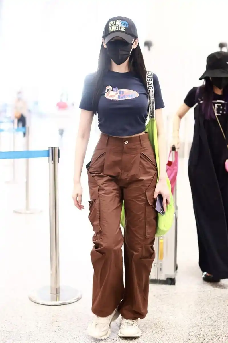 张天爱机场街拍,紧身印花t恤搭配棕色工装裤,棒球帽潇洒自如!