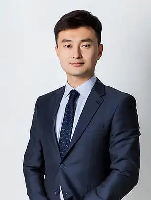 一名西装革履的男子站在股票显示屏前