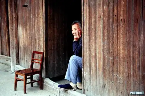 坐在家门口的老人.